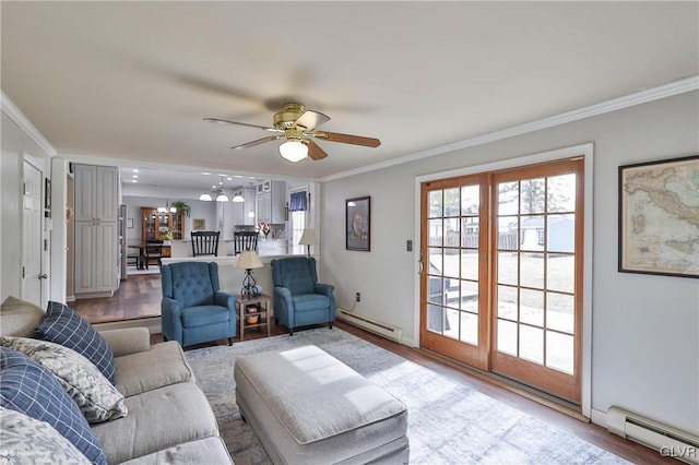 living room featuring a baseboard heating unit, baseboard heating, crown molding, and ceiling fan with notable chandelier