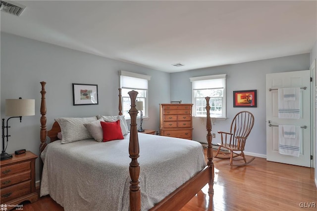 bedroom featuring wood finished floors, visible vents, and baseboards