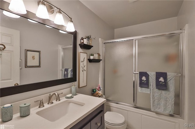 full bath featuring toilet, shower / bath combination with glass door, and vanity