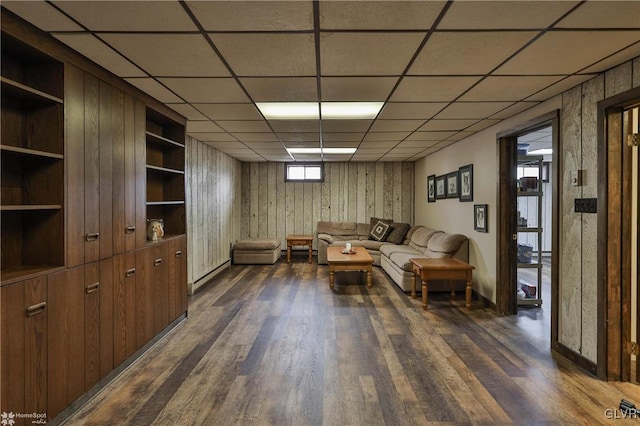 living room with dark wood-type flooring and a paneled ceiling