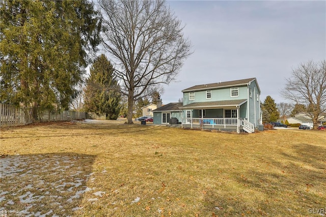 back of house with a yard, covered porch, and fence