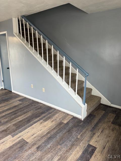 staircase with baseboards and wood finished floors