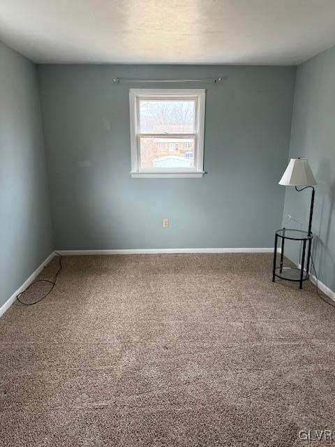 carpeted spare room featuring baseboards