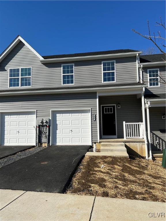 view of front of home featuring driveway, a porch, and an attached garage