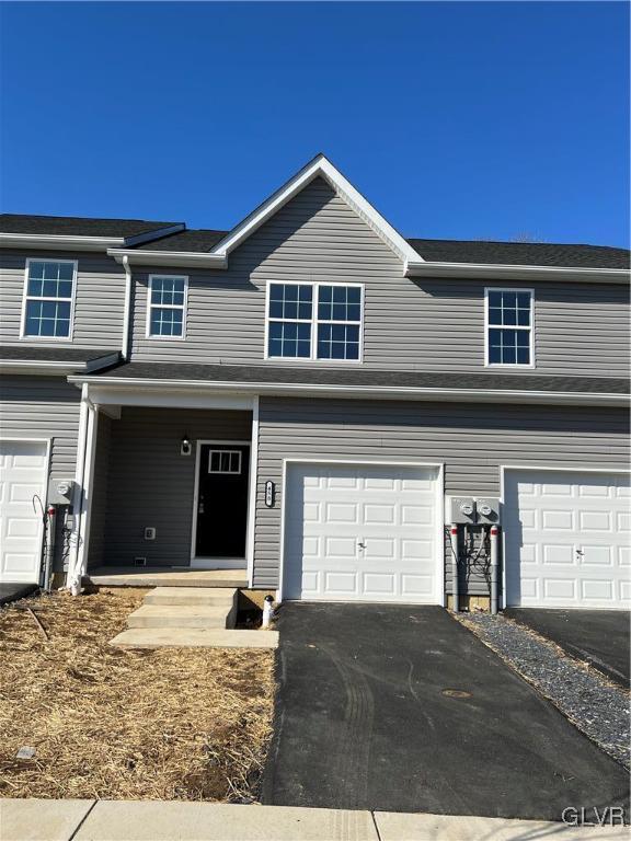 view of front facade featuring an attached garage and aphalt driveway