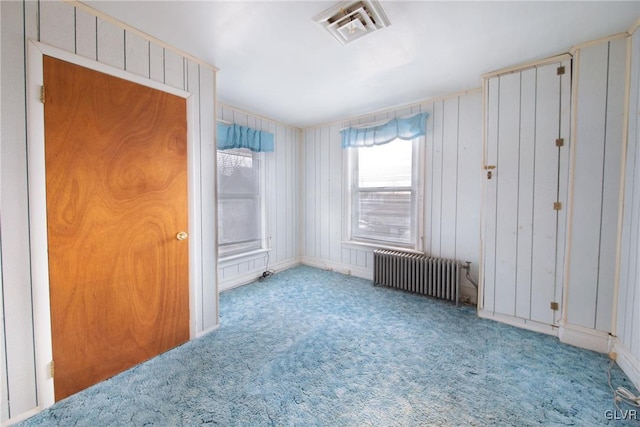 unfurnished bedroom featuring radiator, visible vents, and carpet flooring