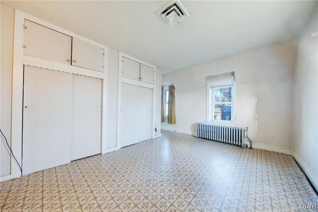 unfurnished bedroom with light floors, two closets, visible vents, radiator heating unit, and baseboards