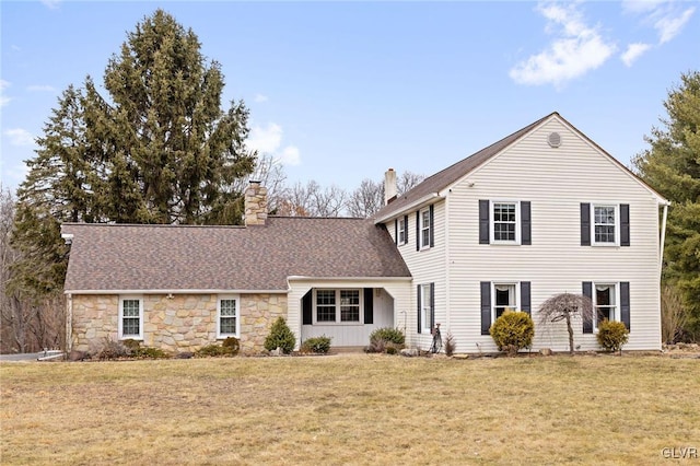 traditional-style house with a front lawn, a chimney, and a shingled roof