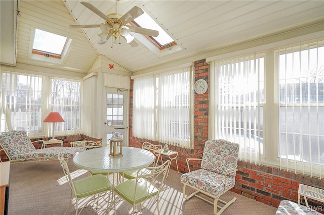 sunroom with lofted ceiling with skylight and ceiling fan