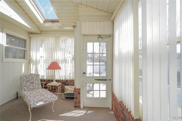 interior space featuring lofted ceiling with skylight and carpet