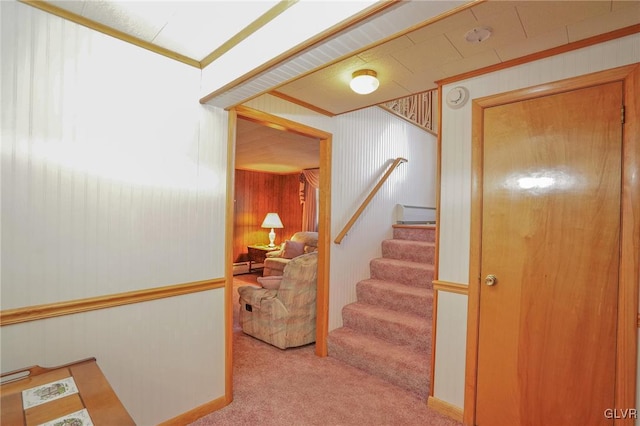 staircase with carpet floors and crown molding