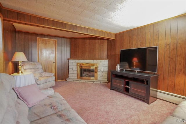 carpeted living room with wood walls, a baseboard radiator, and a stone fireplace