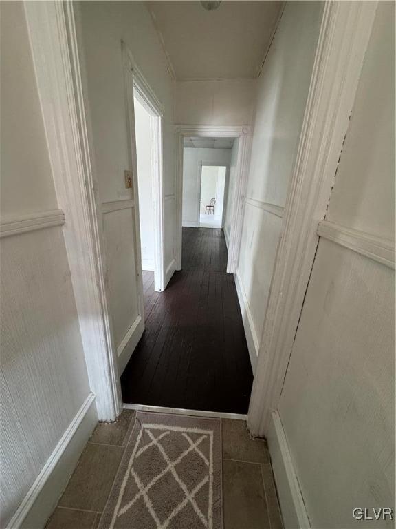 hall with tile patterned flooring and a decorative wall