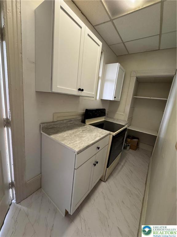 253 N 2nd, Lehighton Boro, PA 18235 - kitchen with range with electric cooktop, light marble finish flooring, white cabinetry, a drop ceiling, and light countertops
