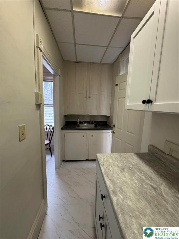 253 N 2nd, Lehighton Boro, PA 18235 - kitchen featuring light marble finish floors, a drop ceiling, and white cabinets