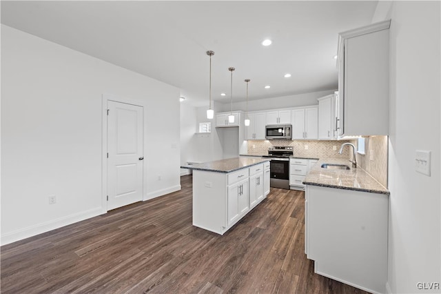 kitchen featuring stone counters, dark wood-style flooring, stainless steel appliances, tasteful backsplash, and a sink