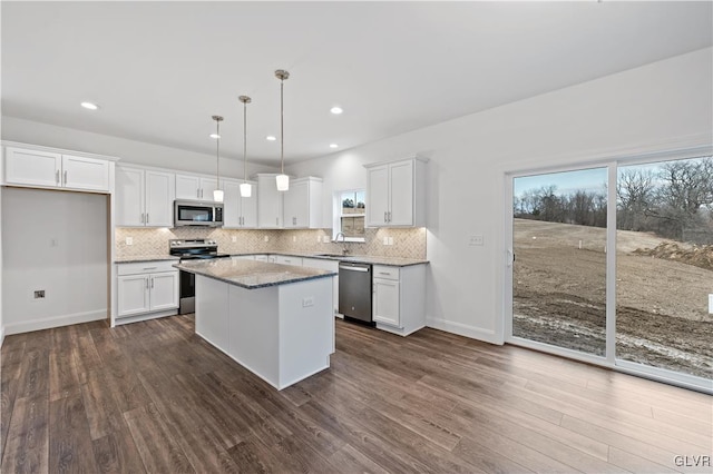 kitchen with decorative backsplash, white cabinetry, stainless steel appliances, and a sink