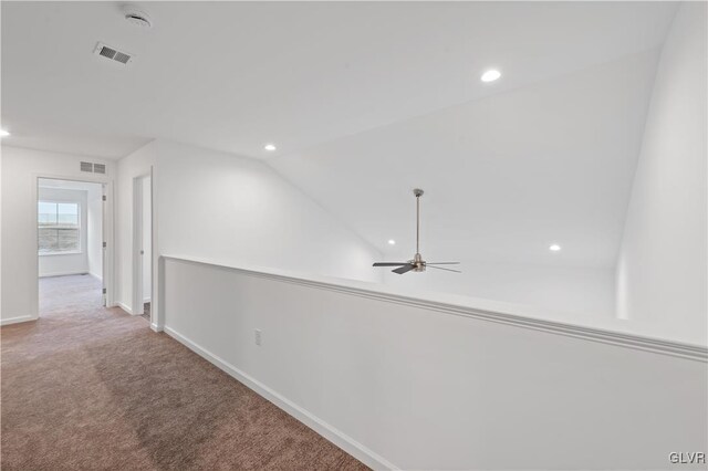 hallway with baseboards, visible vents, lofted ceiling, carpet flooring, and recessed lighting