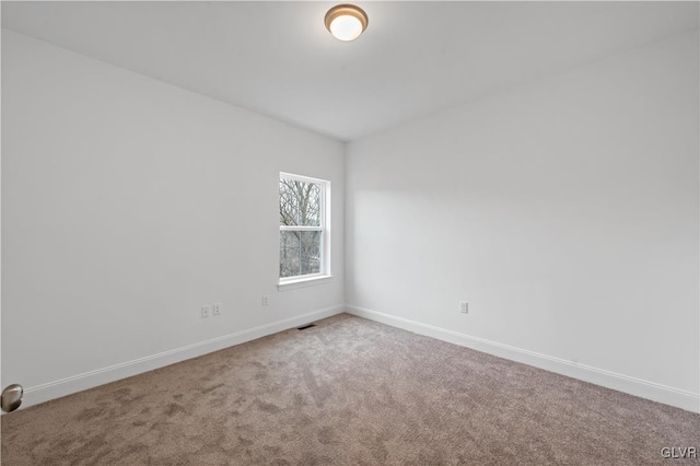 unfurnished room with carpet floors, visible vents, and baseboards