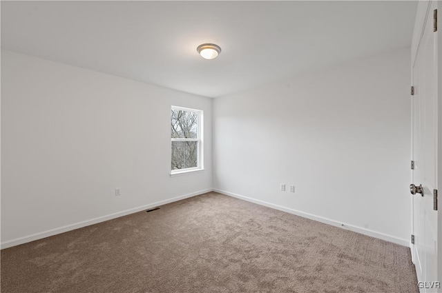 carpeted spare room with visible vents and baseboards