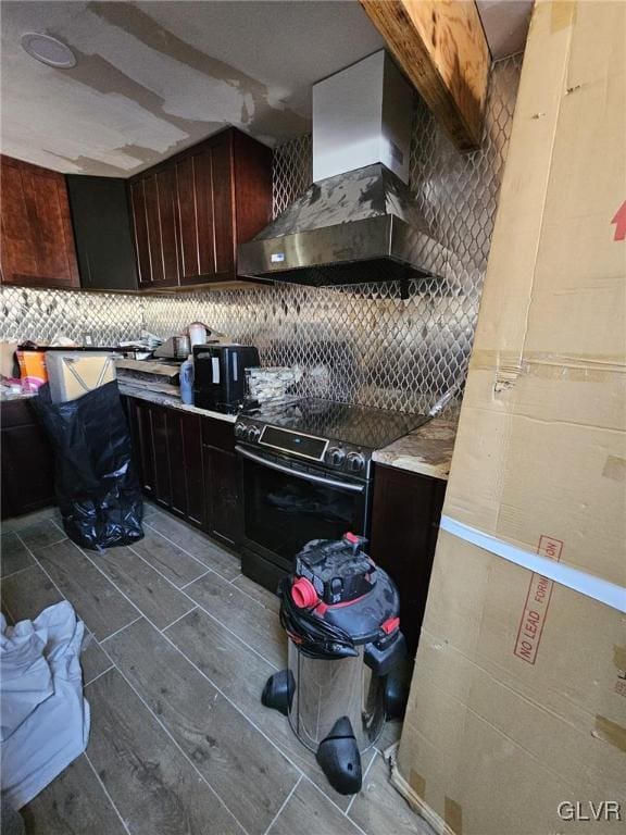 kitchen featuring decorative backsplash, wood finish floors, wall chimney range hood, and electric range oven