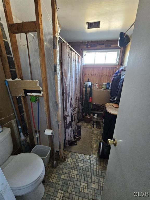 full bathroom with a shower with shower curtain and toilet