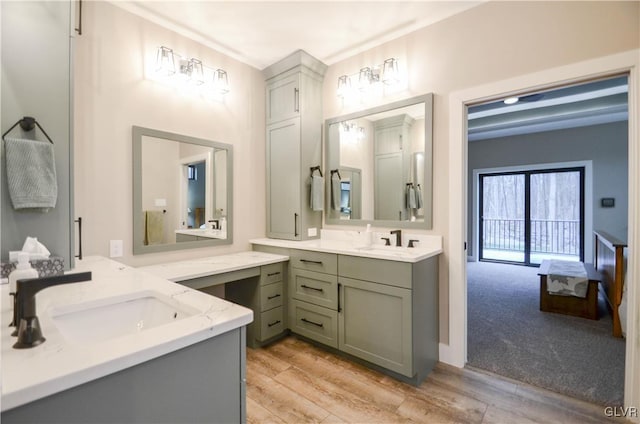 bathroom featuring two vanities, a sink, and wood finished floors