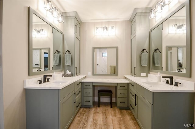 bathroom with two vanities, a sink, and wood finished floors