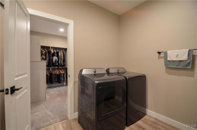 laundry area featuring laundry area, baseboards, washing machine and clothes dryer, and wood finished floors