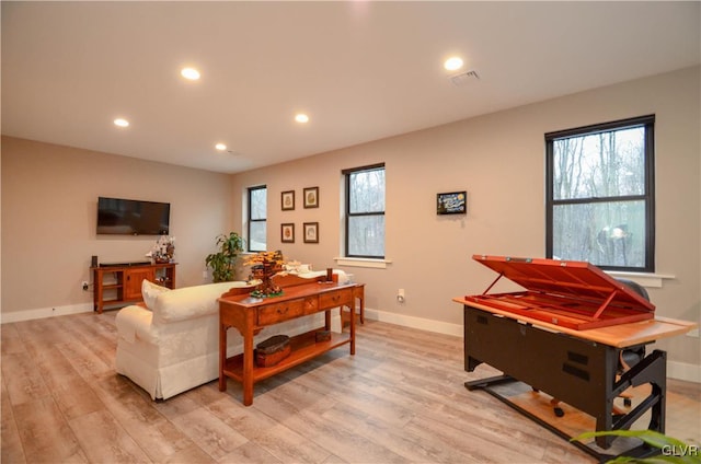 living room featuring a wealth of natural light, visible vents, and light wood-style flooring