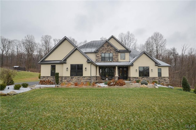 view of front facade featuring stone siding, a front lawn, and stucco siding