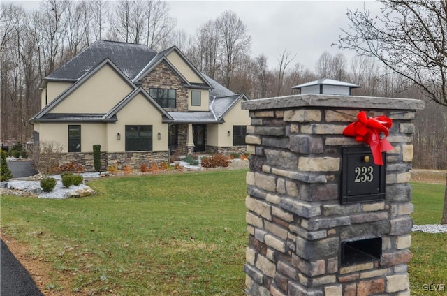 view of front of home with stone siding, a fireplace, a front lawn, and stucco siding