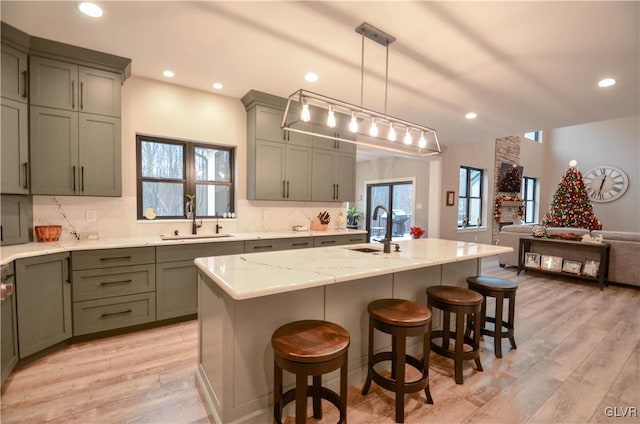 kitchen featuring tasteful backsplash, light wood-type flooring, and a sink