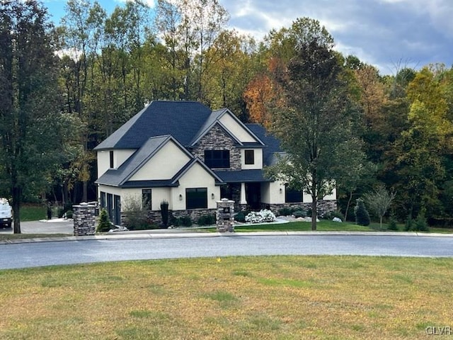 view of front of house with stone siding and a front lawn