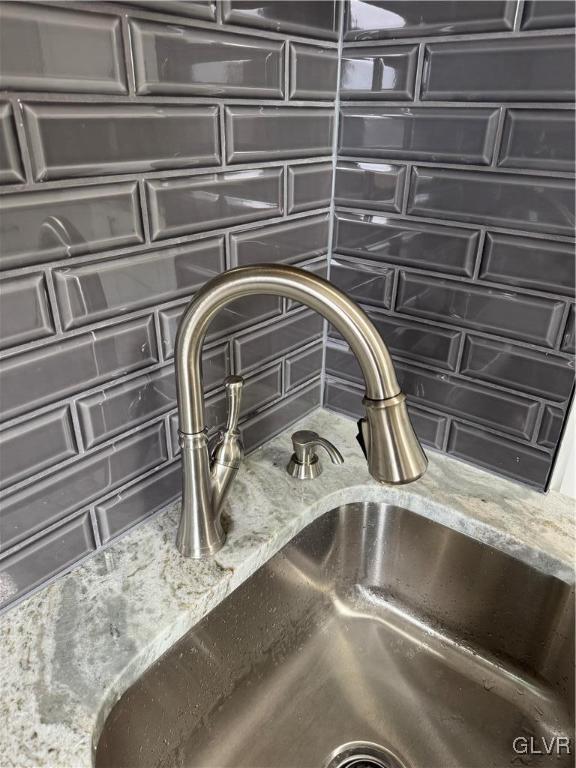 interior details with light stone counters and a sink