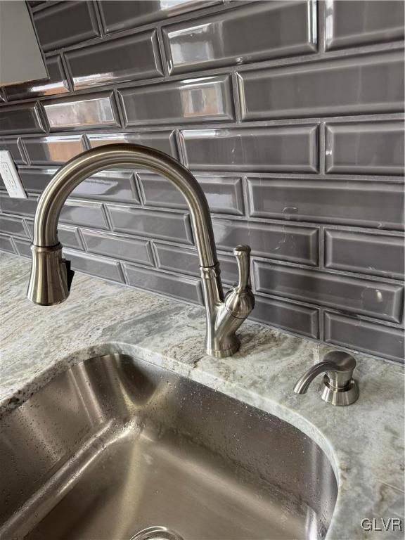 details with a sink and decorative backsplash