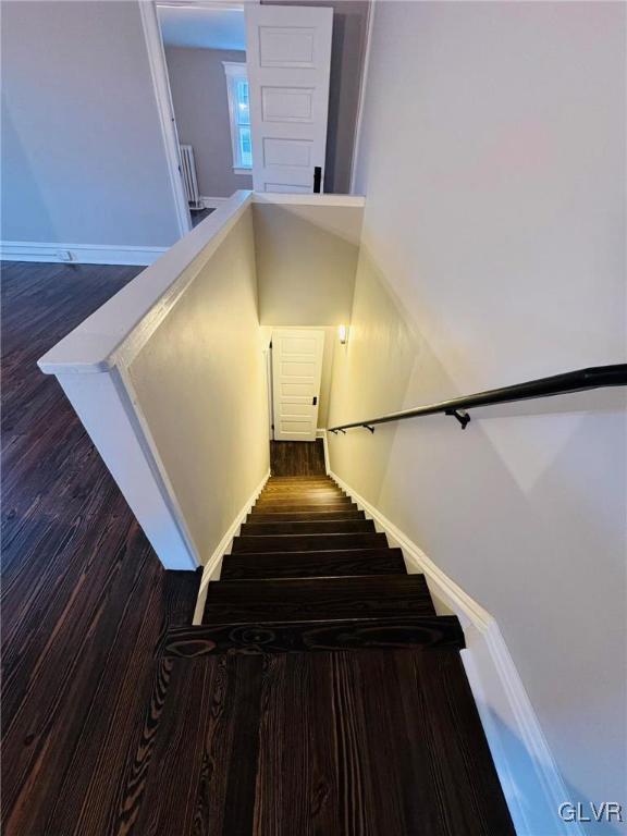 stairs with wood finished floors and baseboards