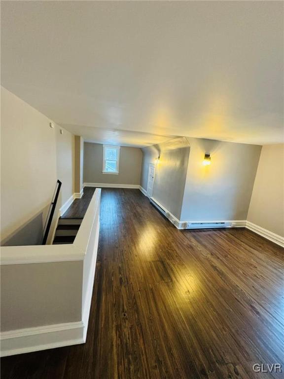 unfurnished living room featuring baseboards and wood finished floors