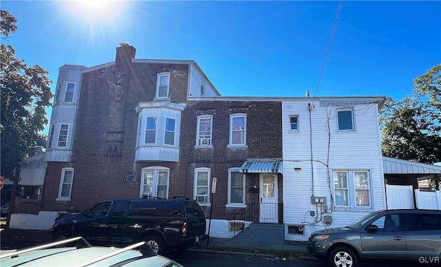 view of front of home with brick siding and a chimney