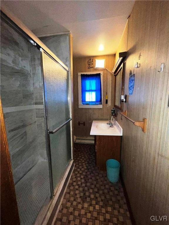 bathroom with a shower stall, wooden walls, and vanity