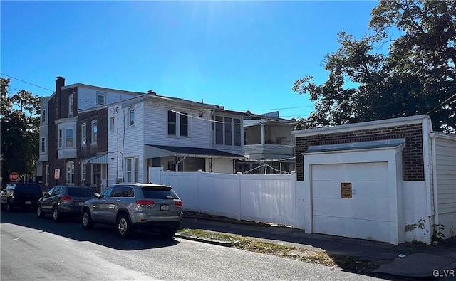 view of front of property with a garage, brick siding, and fence