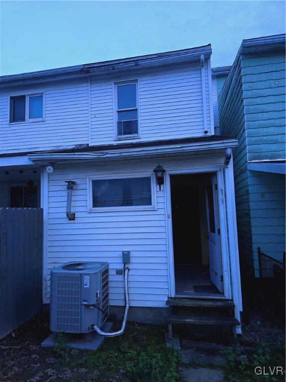 back of house with central air condition unit and fence