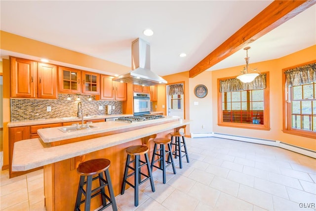 kitchen featuring island range hood, stainless steel appliances, a sink, light countertops, and tasteful backsplash