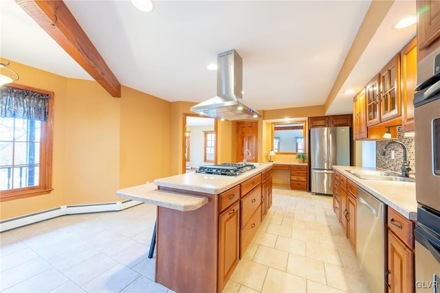 kitchen featuring brown cabinetry, island exhaust hood, stainless steel appliances, light countertops, and a sink