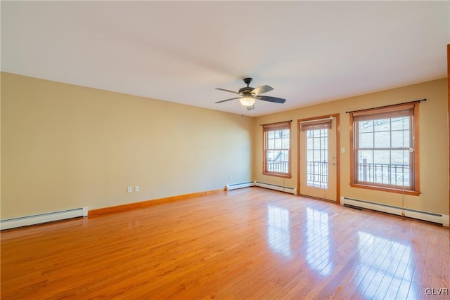 unfurnished room featuring a baseboard heating unit, light wood finished floors, baseboard heating, and baseboards