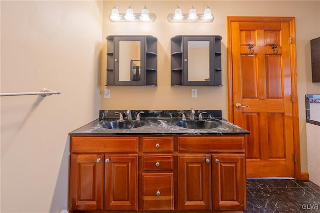 bathroom with double vanity, marble finish floor, and a sink