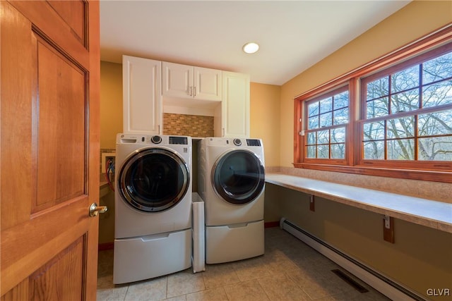 washroom with light tile patterned floors, separate washer and dryer, a baseboard radiator, and cabinet space