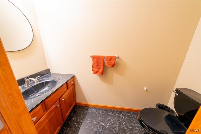 bathroom featuring marble finish floor, vanity, toilet, and baseboards