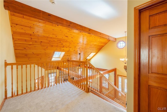 additional living space featuring a skylight, an inviting chandelier, carpet flooring, high vaulted ceiling, and beamed ceiling