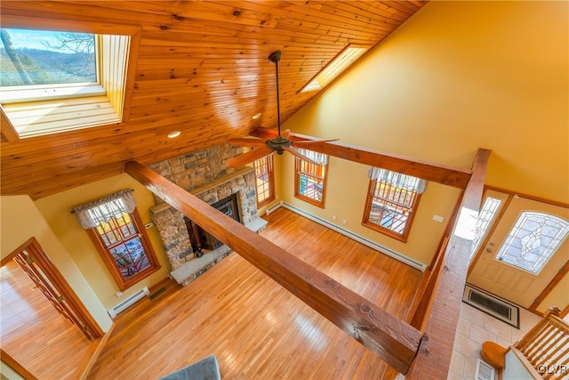 stairs with a skylight, visible vents, a fireplace, and wood finished floors